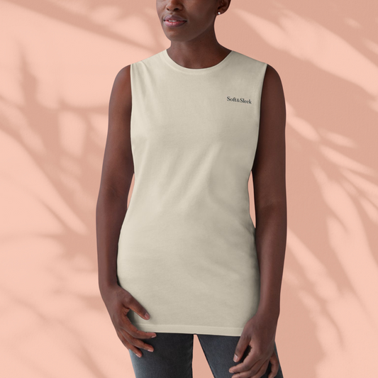 Person wearing a beige sleeveless shirt with 'Soft & Shelter' logo on a peach background