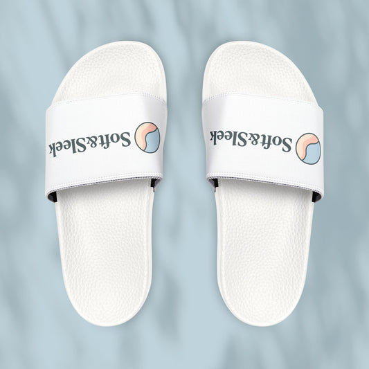 Flat lay top view of Soft & Sleek white slides showing the logo and emblem, placed on pale blue background
