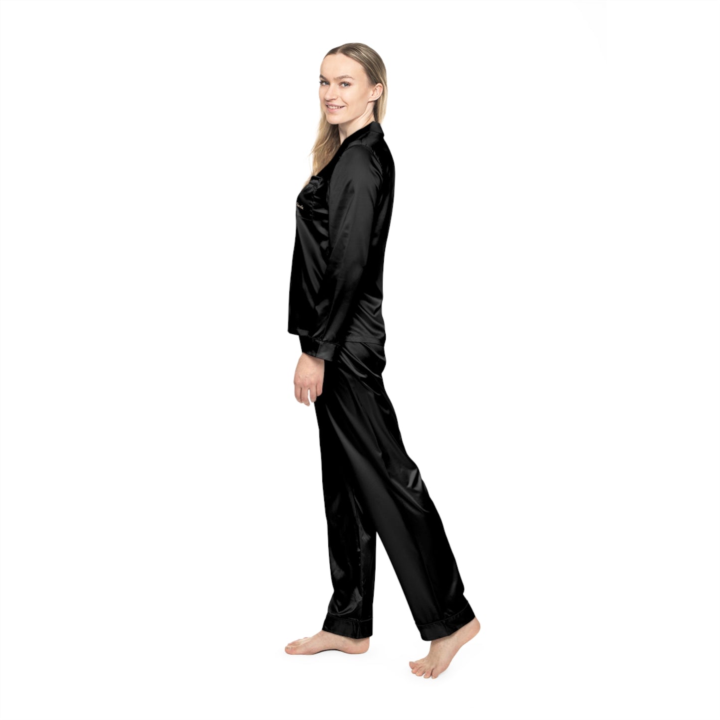 Profile view of woman wearing black Soft & Sleek satin pyjamas, looking over shoulder.