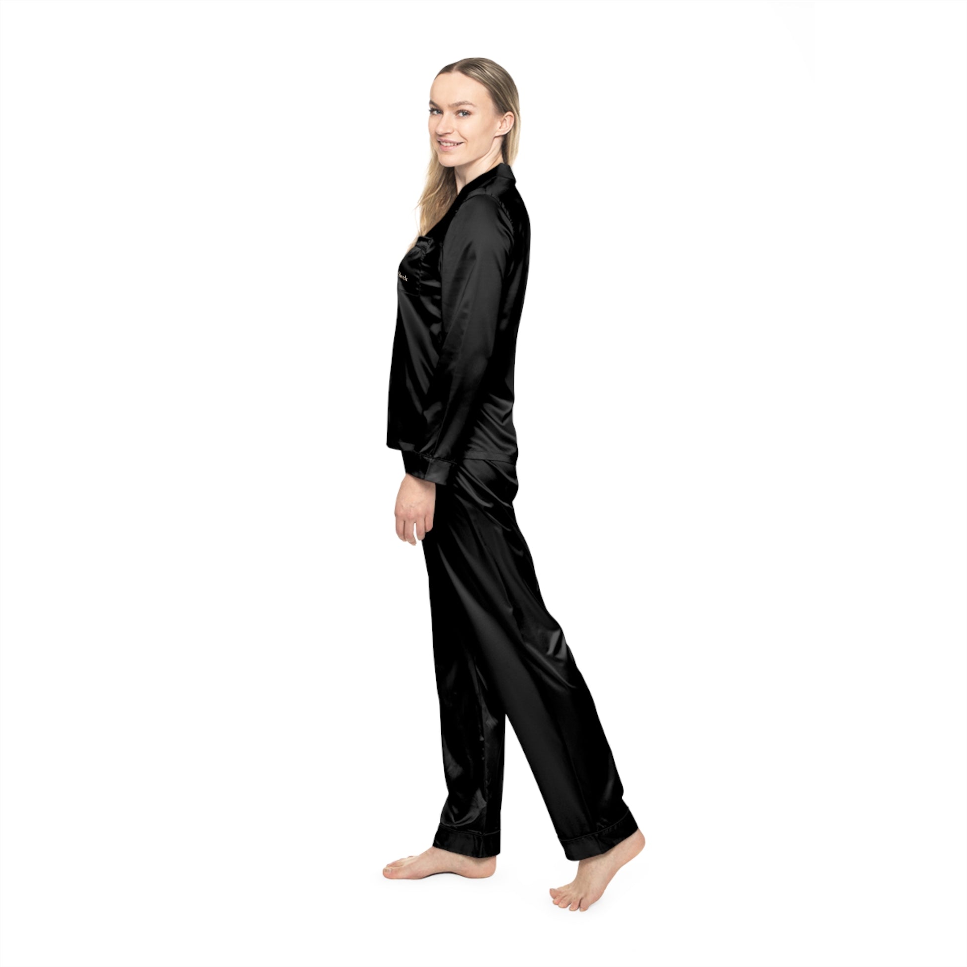 Profile view of woman wearing black Soft & Sleek satin pyjamas, looking over shoulder.
