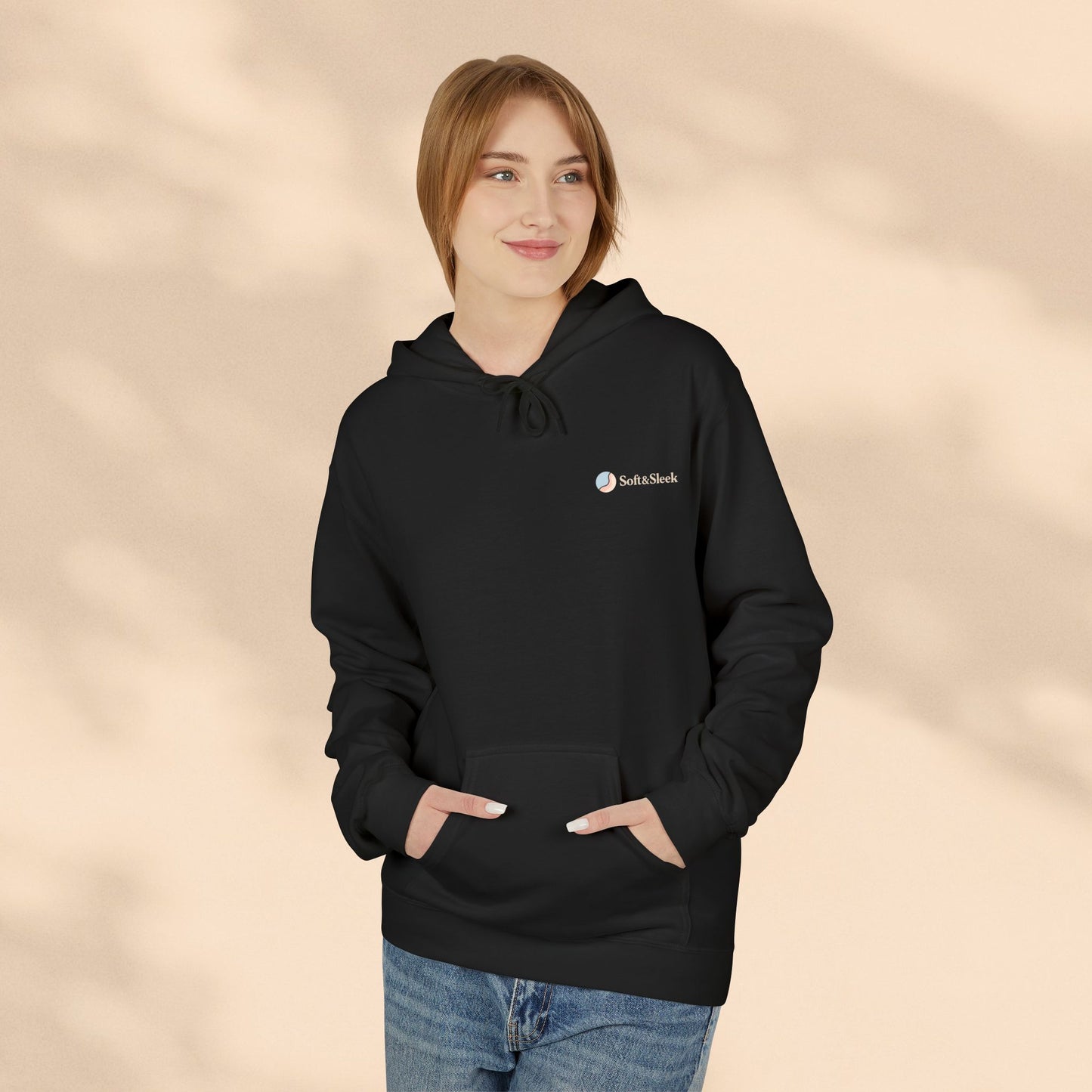 Person wearing a black hoodie with a logo on a beige background
