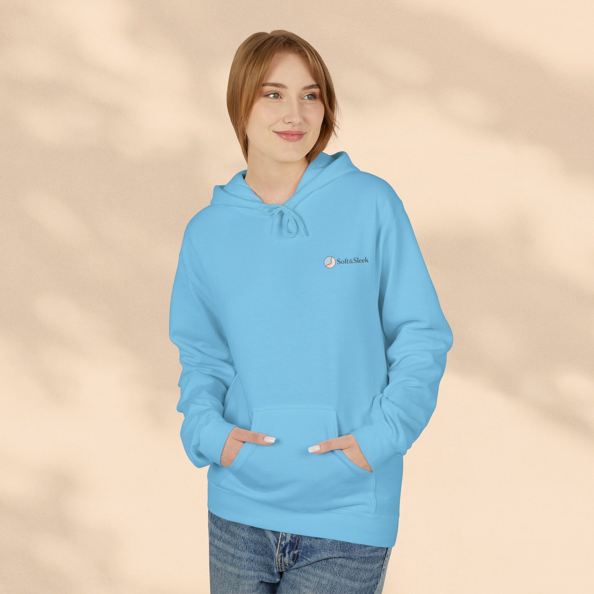 Person wearing a light blue hoodie with a brand logo on a beige background
