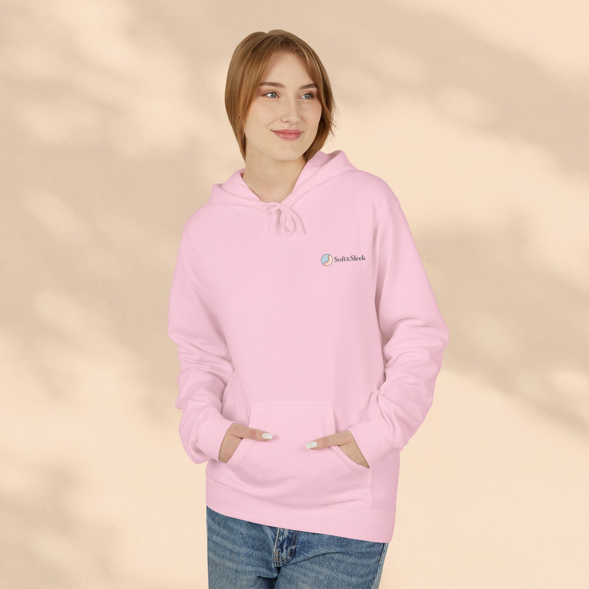 Woman wearing pink Soft & Sleek hoodie with hands in pocket, beige background