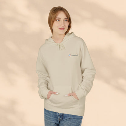 Woman wearing beige Soft & Sleek hoodie with small chest logo, hands in pocket, beige background