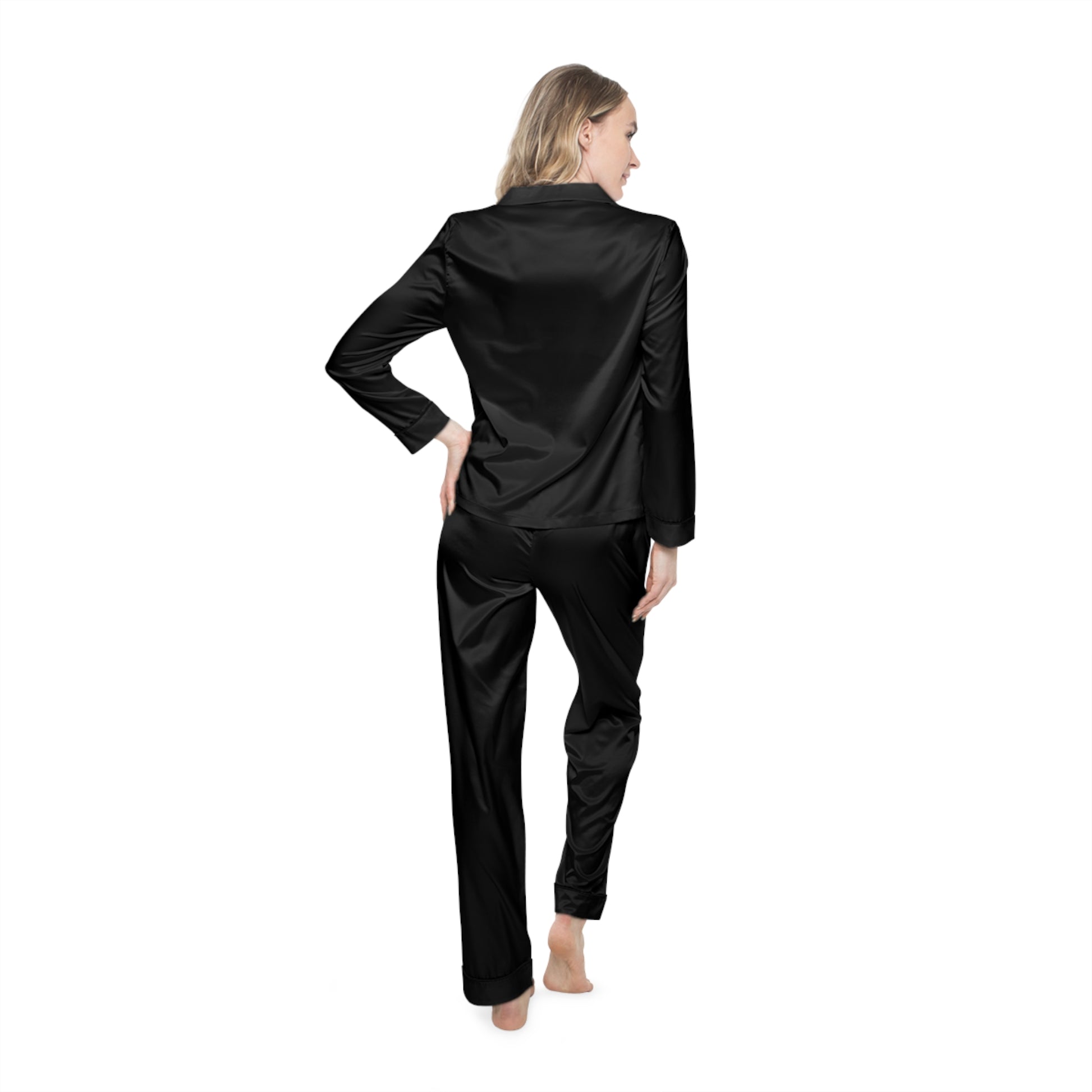 Rear view of woman in black Soft & Sleek satin pyjamas with relaxed pose and hand on hip.