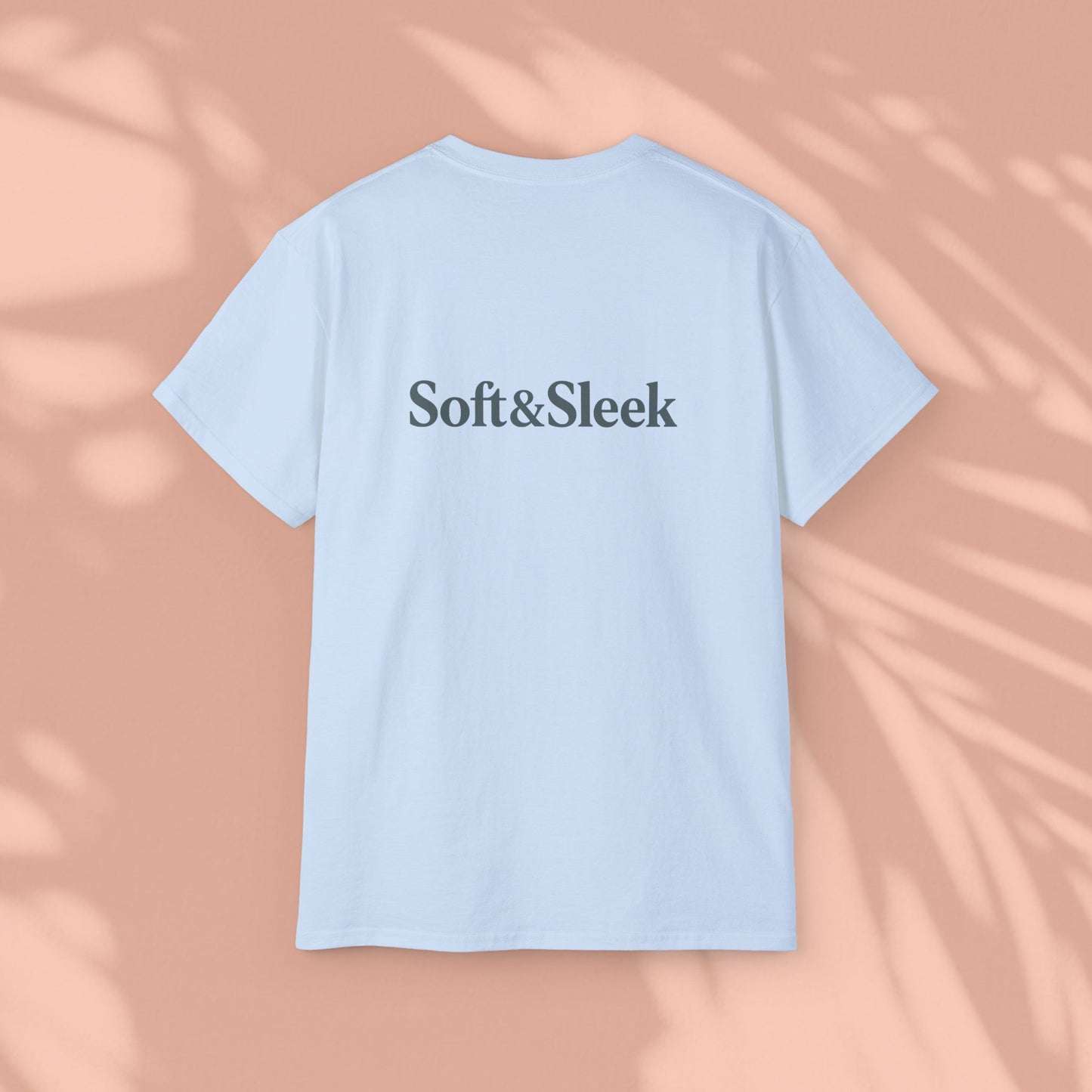 Light blue Soft & Sleek t-shirt with logo on chest, peach background