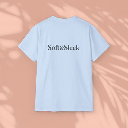 Light blue Soft & Sleek t-shirt with logo on chest, peach background