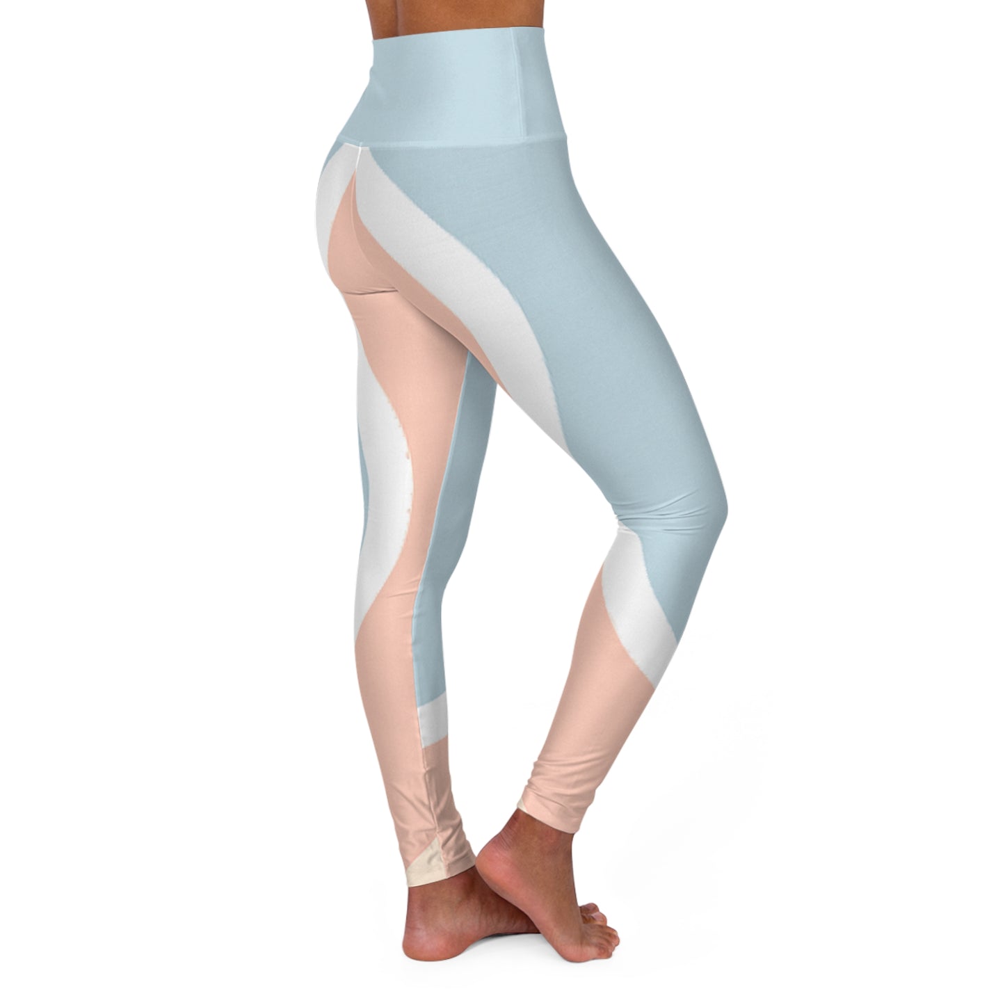 Angled rear-side view of pastel blue cropped leggings with sweeping white and peach accents, barefoot model crossing legs