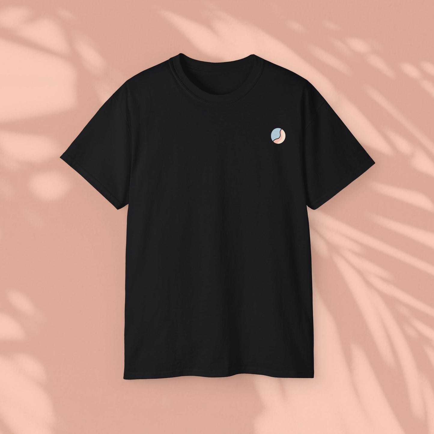 Black Soft & Sleek t-shirt with circular emblem, peach background