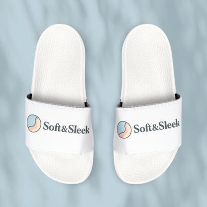 Flat lay of Soft & Sleek white slides placed side by side with visible logo and emblem, pale blue background