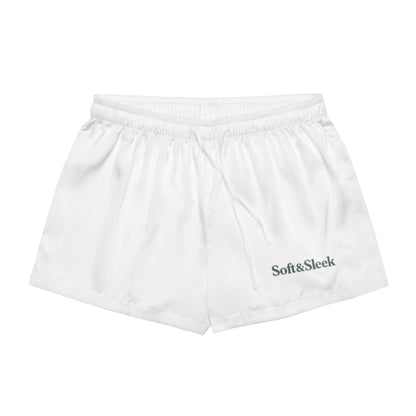 Flat lay of white Soft & Sleek lounge shorts with logo printed on the lower leg, front-facing.