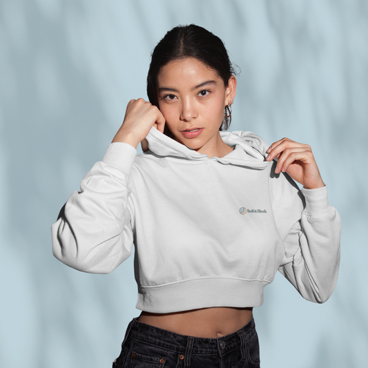 Person wearing a light gray hoodie with a brand logo on a light blue background
