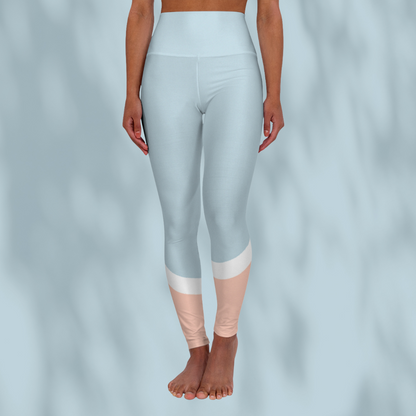 Front view of woman wearing pastel blue cropped Soft & Sleek leggings with peach and white colour-block detail at calves, pale blue background