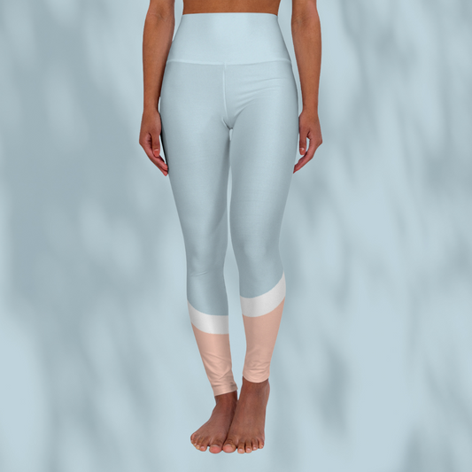 Front view of woman wearing pastel blue cropped Soft & Sleek leggings with peach and white colour-block detail at calves, pale blue background