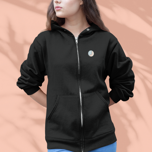 Black zip-up hoodie with a small logo on a peach background