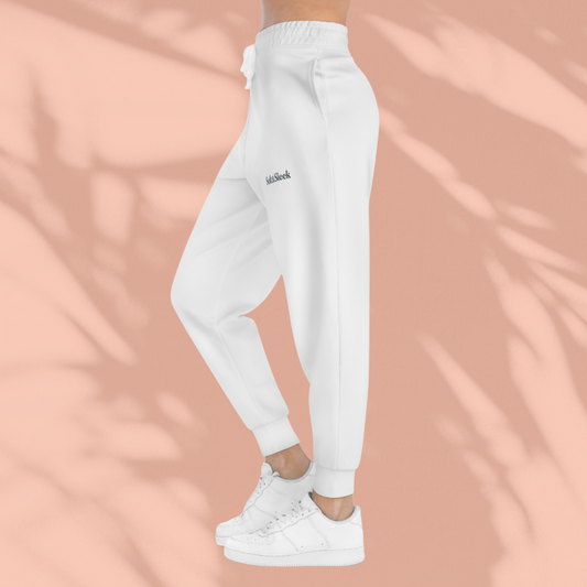 Side view of woman wearing white Soft & Sleek joggers with drawstring waist and logo on thigh, paired with white trainers, peach background