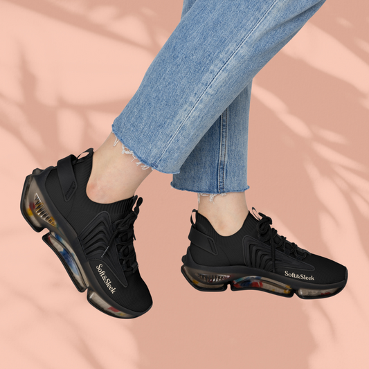 Side view of a person wearing black Soft & Sleek trainers with iridescent sole, mid-air against a peach background.